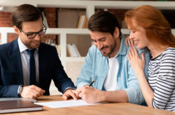 Pareja de adultos jóvenes firmando y finalizando su compra de vivienda cusezar